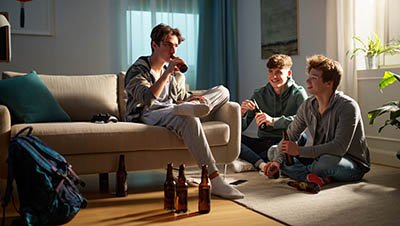 Мальчики подростки пьют пиво в квартире